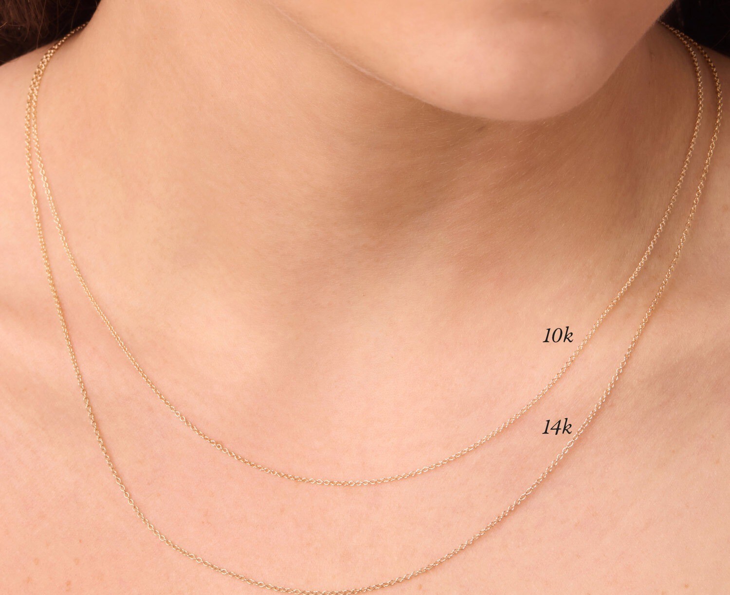 Two Catbird chains worn together and labeled 10k and 14k: the karat number's color difference, read side by side