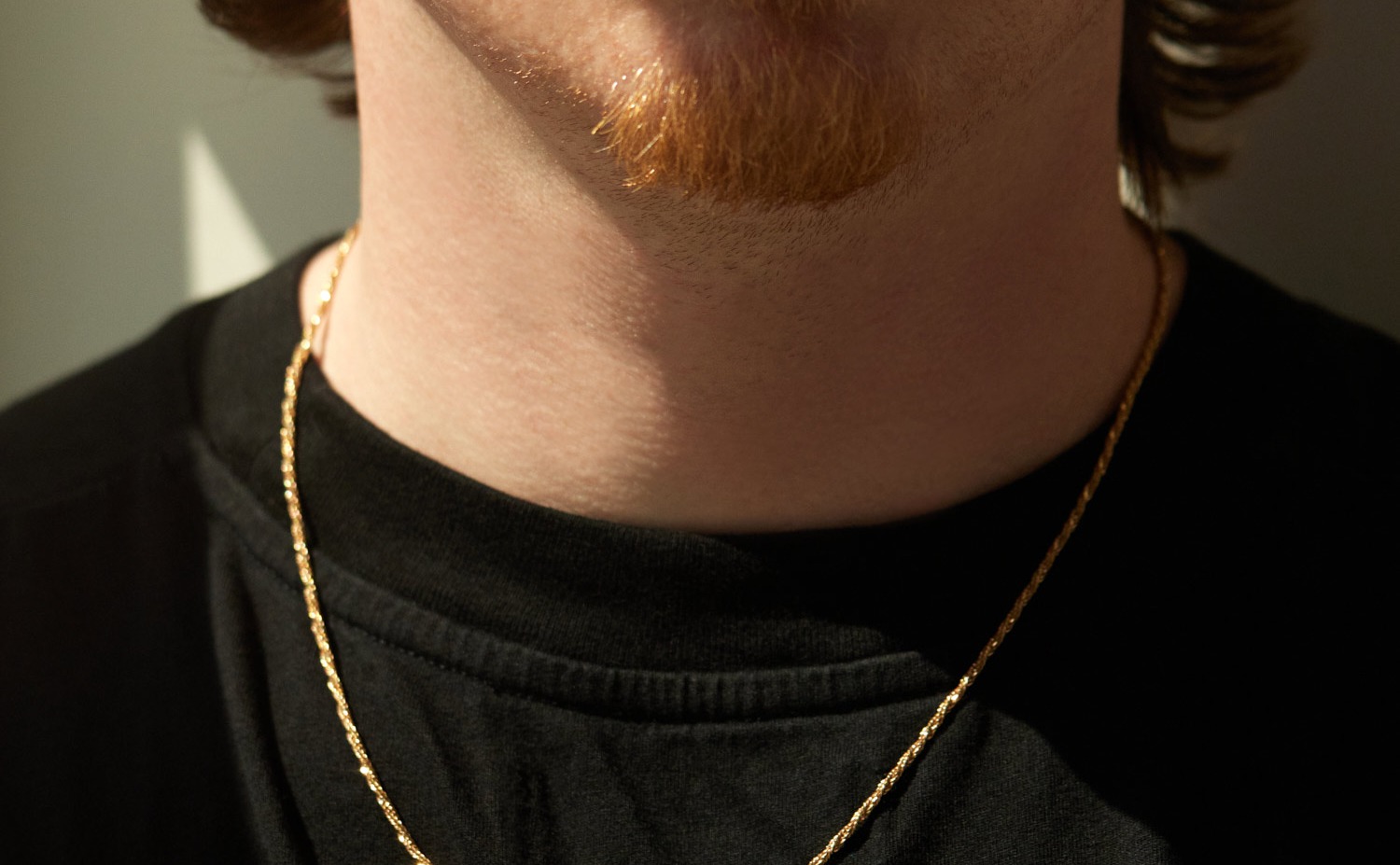 Solid 14k yellow gold chain worn over a black tee: Catbird's Lover's Chain, where chain and clasp karat are both stated