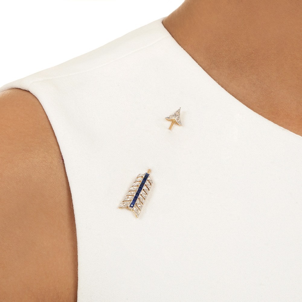 An Art Deco jabot pin worn through fabric with both ornamented ends showing, the kind of lapel jewel from the decades when a man's chest was jewelry territory