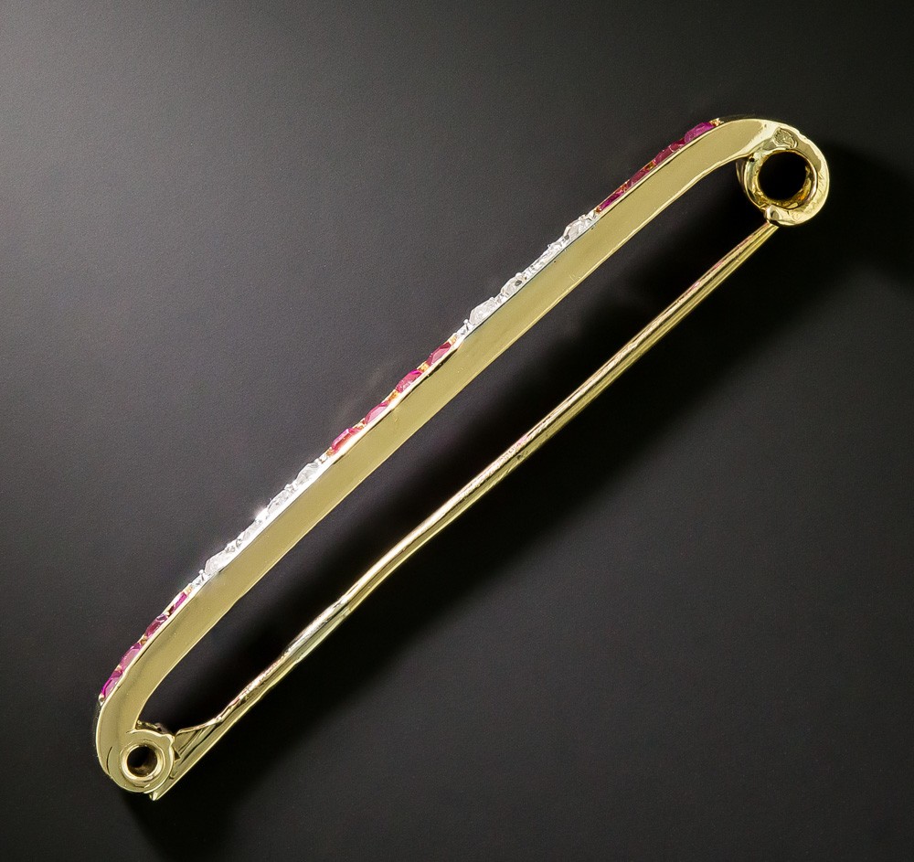 The reverse of an estate bar brooch showing its pin stem and rollover safety catch, the mechanical check that matters most when buying a vintage brooch