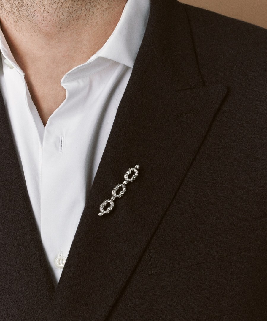 A fine diamond brooch worn on a man's suit lapel, reflecting that the newest interest in the brooch is coming from men