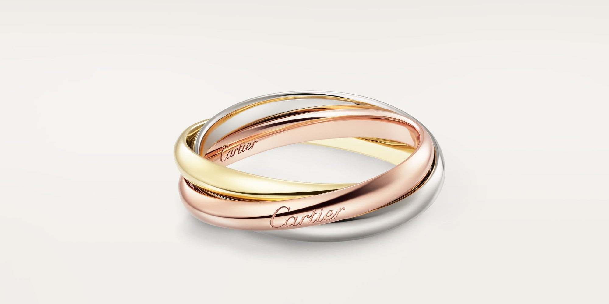 Trinity ring by Cartier, small model: three interlocking bands of white, yellow, and rose gold. Image courtesy of Cartier.
