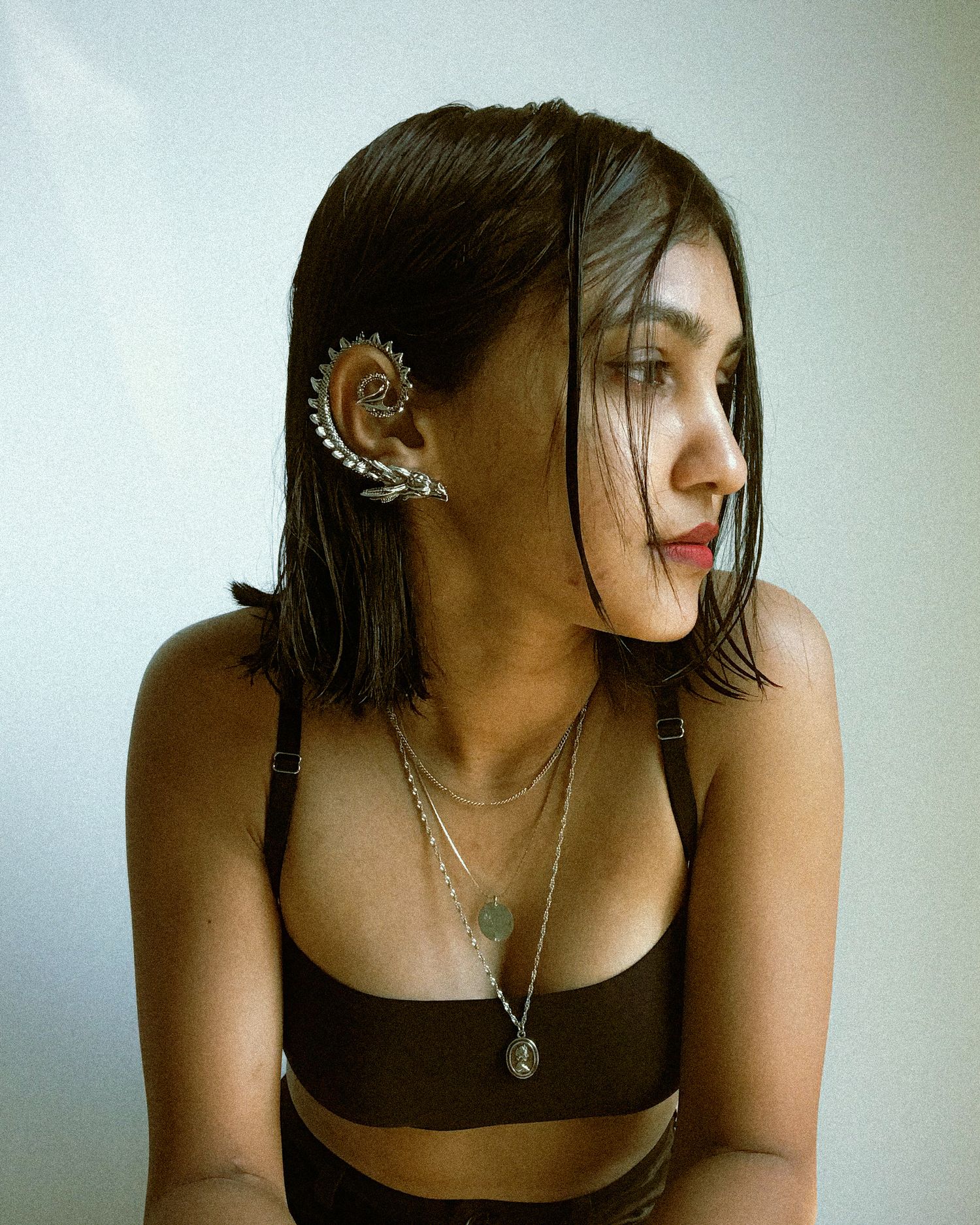 An ornate silver ear-climber cuff wrapping the whole ear, the elaborate end of fine jewelry made for the ear.