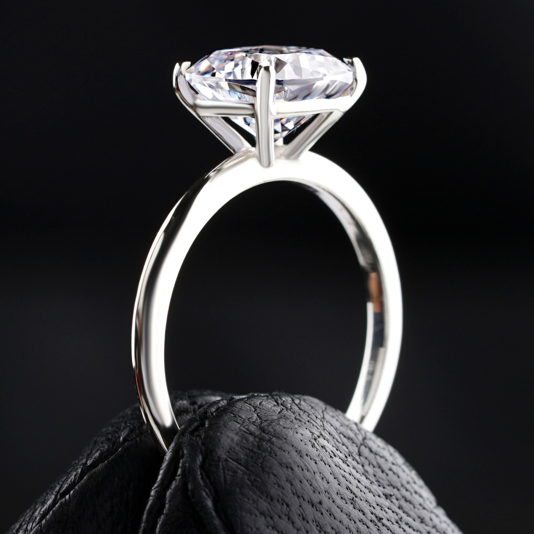 A prong-set solitaire viewed from the side at eye level, the table sitting level and the prongs meeting the girdle