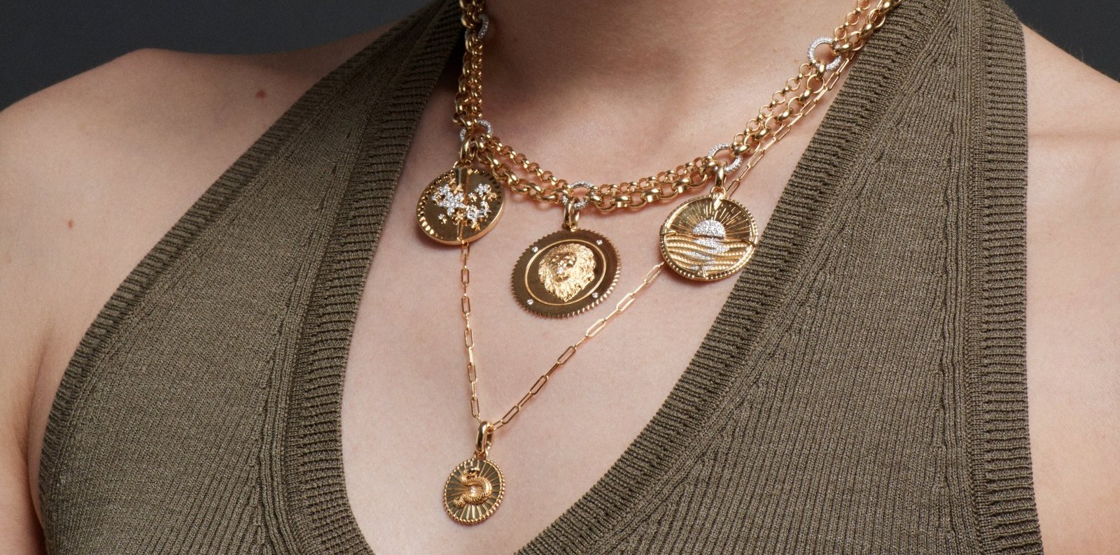 A woman wears several Foundrae talismanic medallions layered on gold chains, the collected-medallion look whose resale retention keeps pointing back to the same independent names.