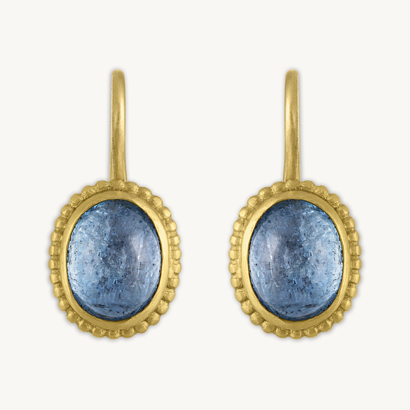 A pair of Prounis earrings up close, aquamarine cabochons ringed in hand-fused granulation, the tiny spheres of 22 karat gold fused one at a time that nearly always sell through the house's tiny resale supply.