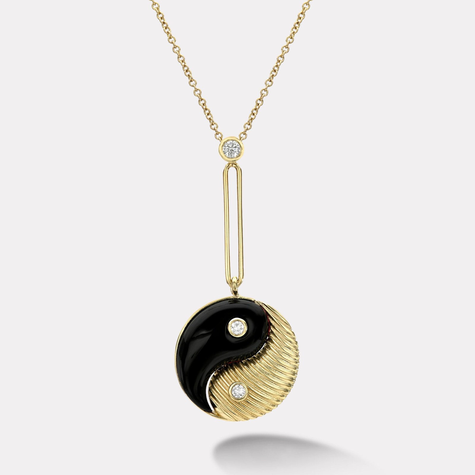 A Retrouvai Yin Yang pendant in black onyx and gold, one of the substantial made-to-order talismans that hold on the resale market, the real thing to enter through rather than the Mini Compass that discounts.