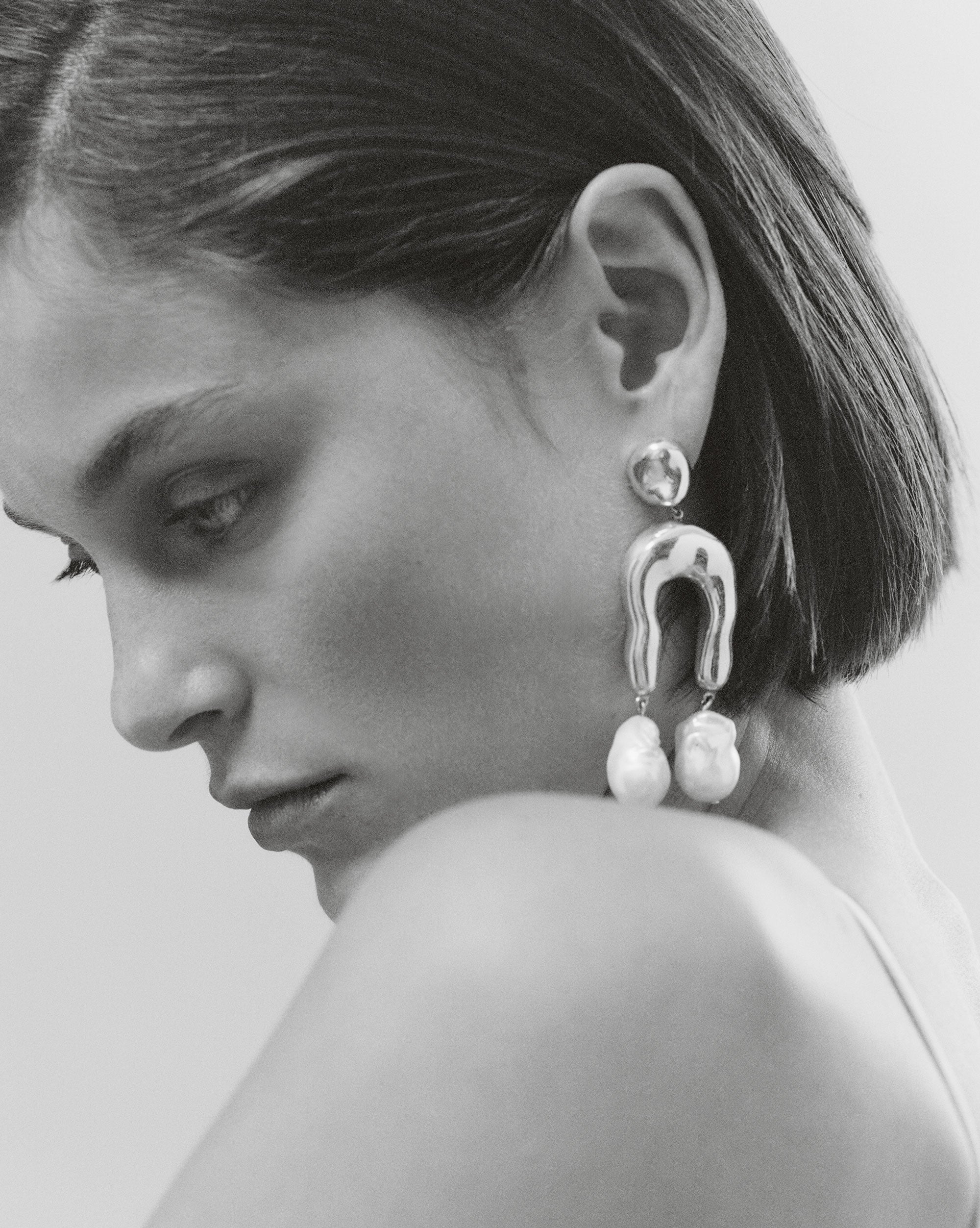 AGMES Imogene Earrings on model, a large asymmetric drop built around a freshwater pearl. Image courtesy of AGMES.