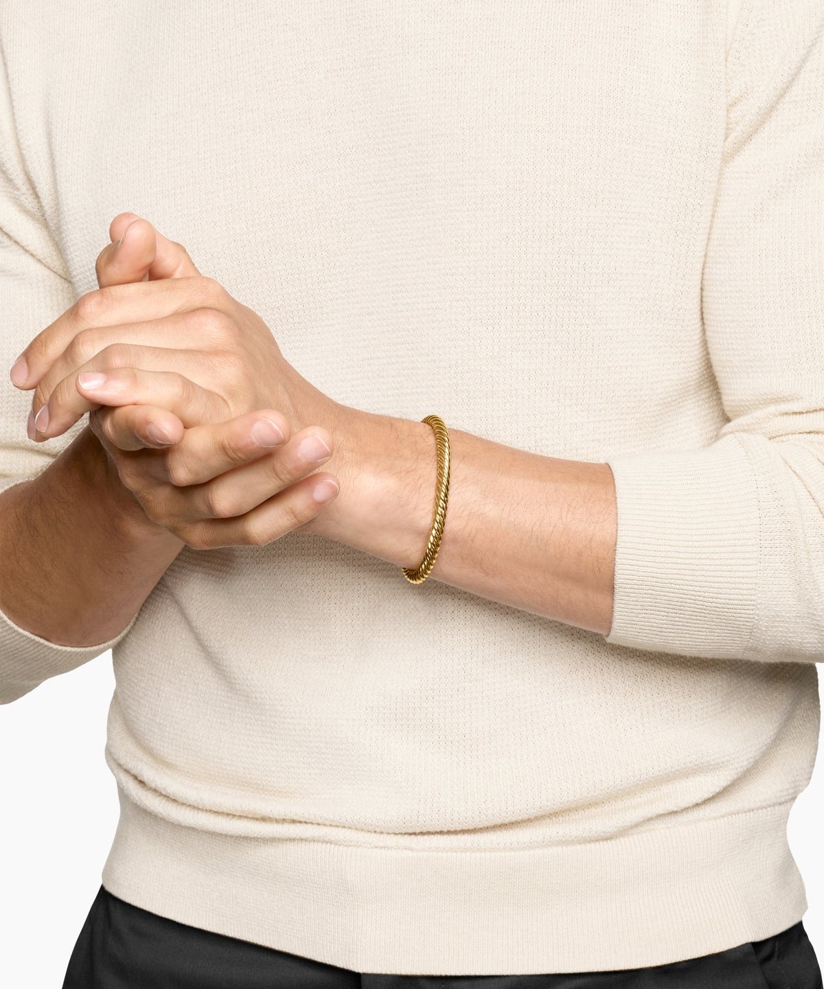 A man's wrist in David Yurman's twisted-rope 18k gold Cable cuff, the men's gold bracelet as the category's open move where taste can get ahead of the market