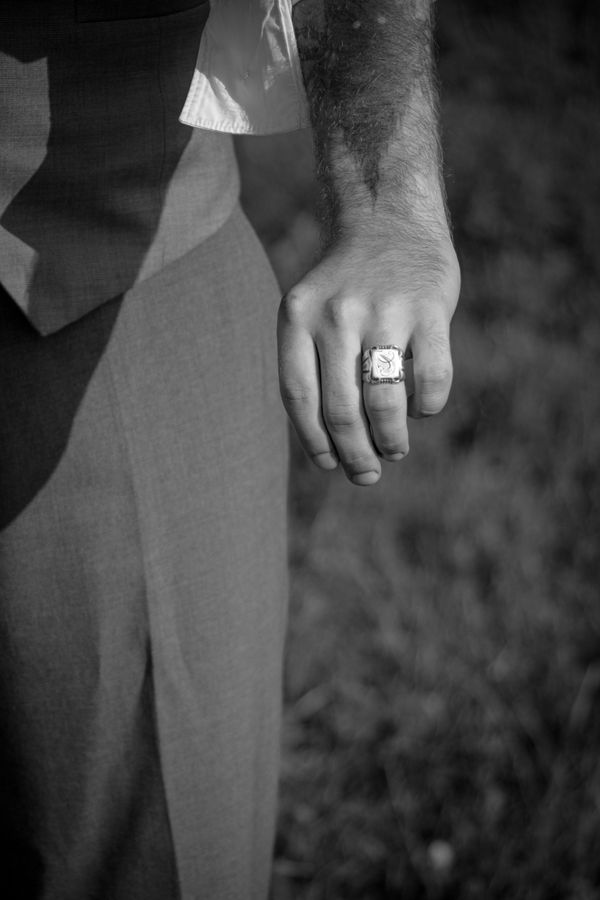 A man in a suit with a signet ring on his hand, the kind of rank-marking ornament men wore openly for most of jewelry's history