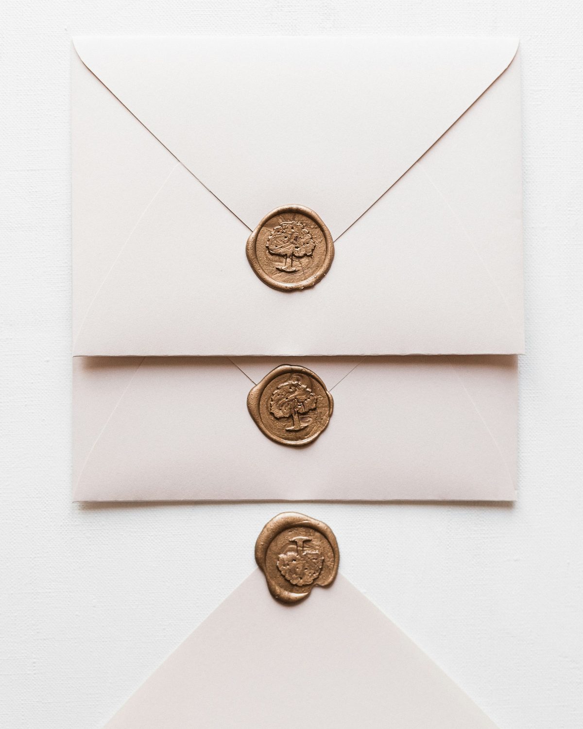 Gold wax seals pressed with a crest motif on cream envelopes, the kind of impression a signet ring was built to make, because the signet is a seal you wear and its engraved face was always the point.