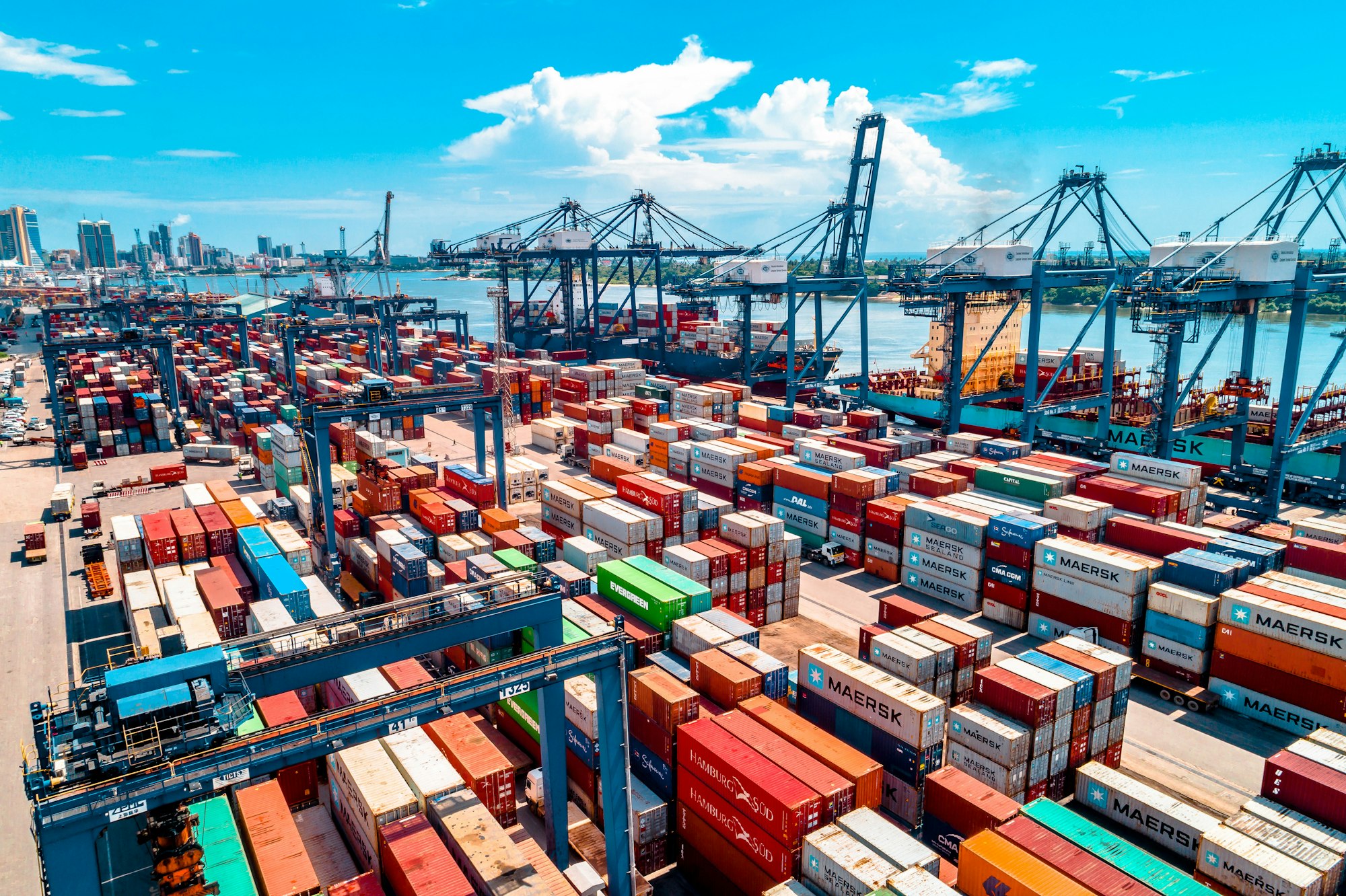 Aerial view of a container port stacked with Maersk shipping containers and gantry cranes