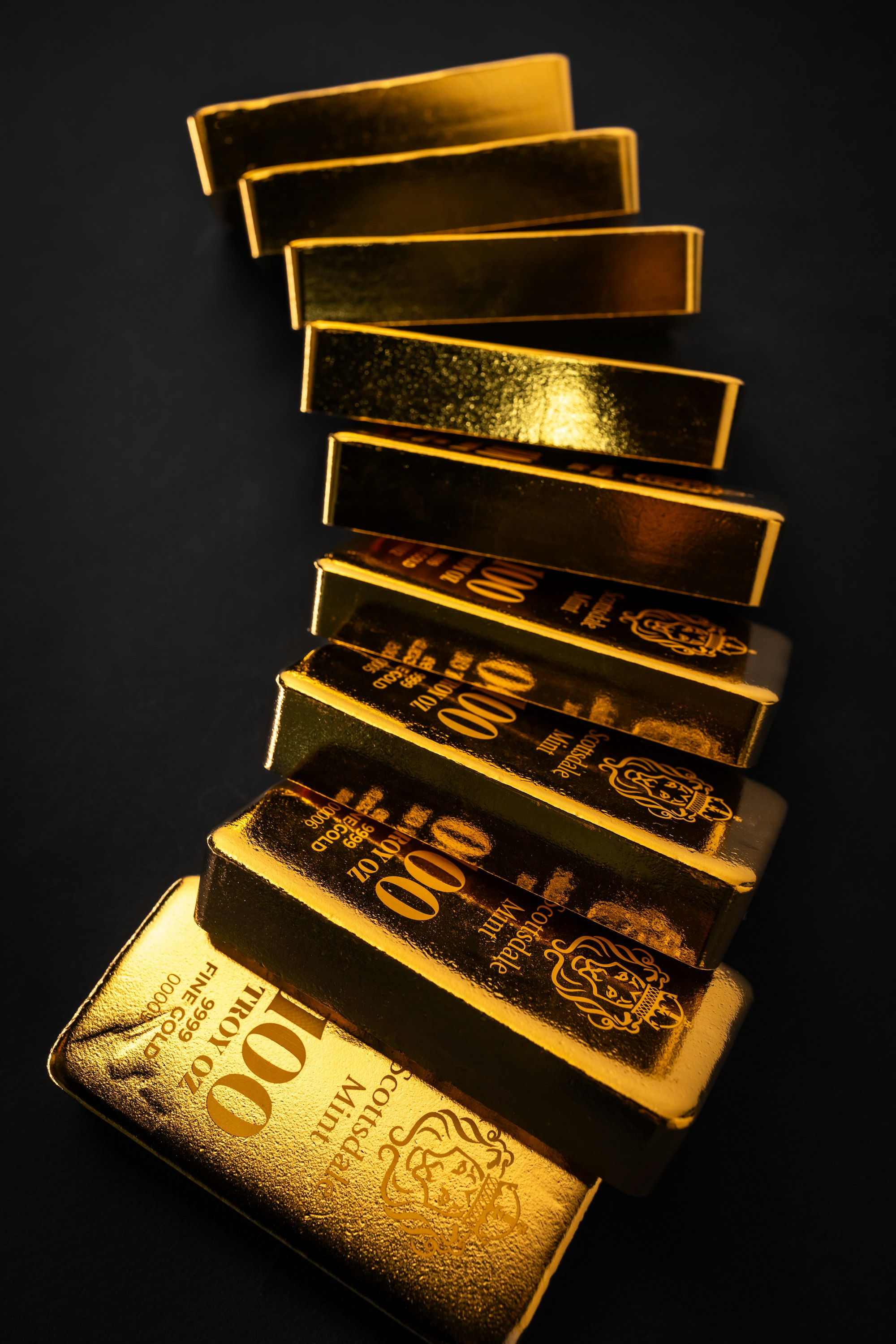 Gold bars stacked on a dark surface